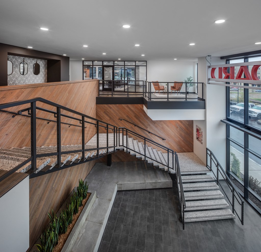 the lobby of a building with stairs and a wooden ramp