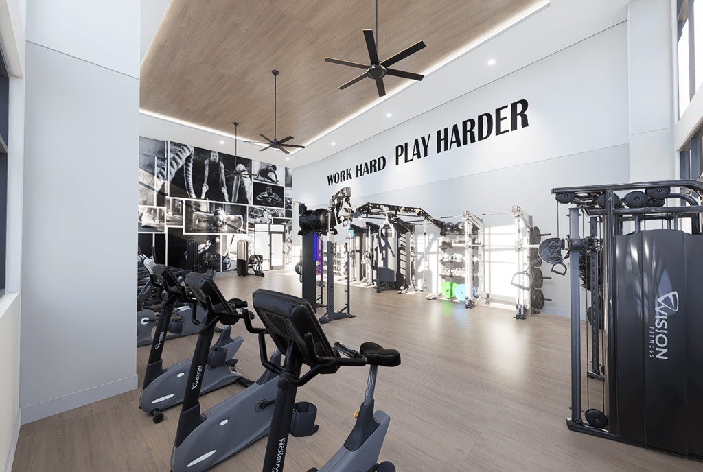 A gym with a variety of equipment and a sign that says "Work Hard Play Harder".