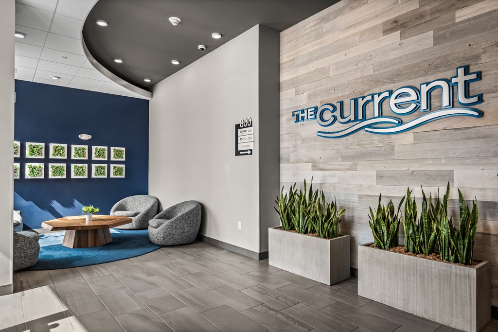 the current office lobby with chairs and a table and the sign for the current