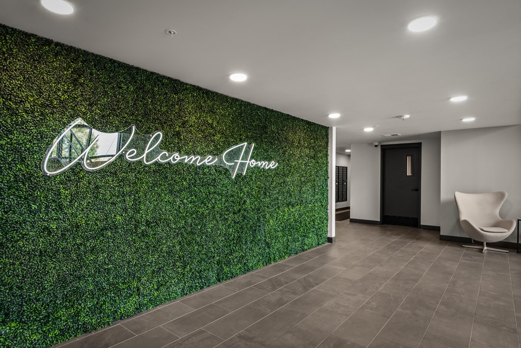 a lobby with a green wall with a welcome sign on it