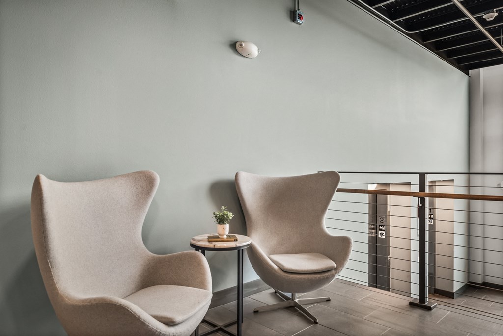 two chairs in a room with a railing and a table