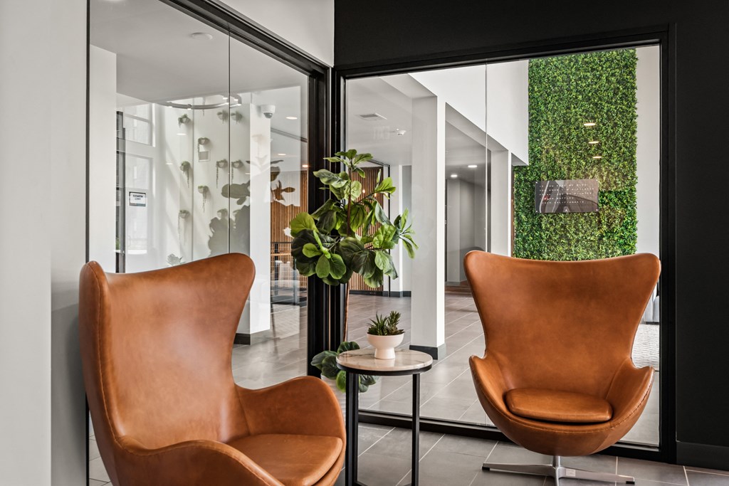 a living room with two brown chairs and a green wall