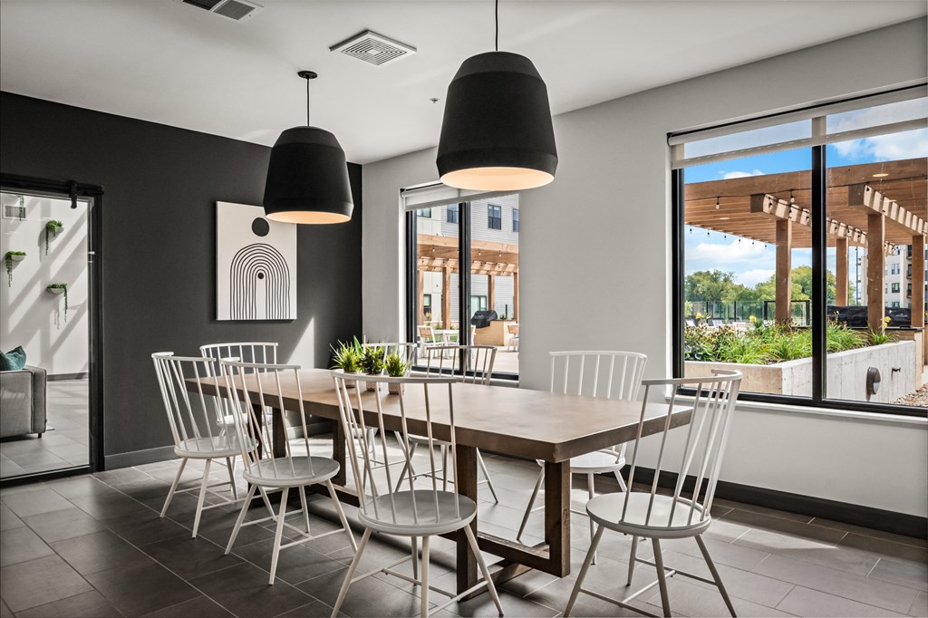 a dining room with a wooden table and white chairs