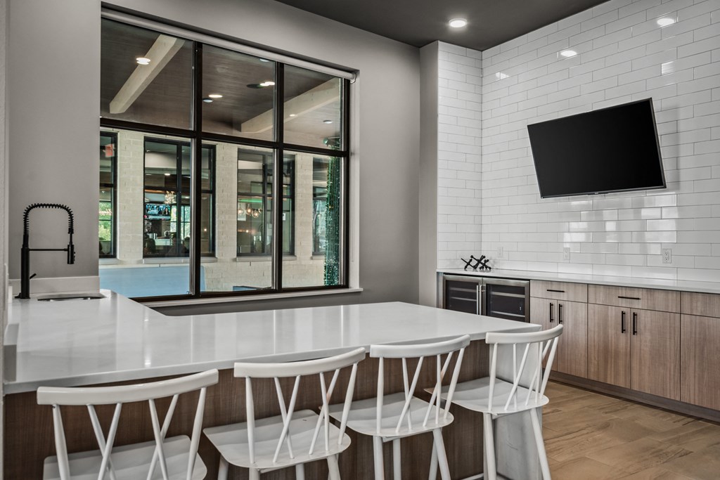 a kitchen with a white counter top and white chairs