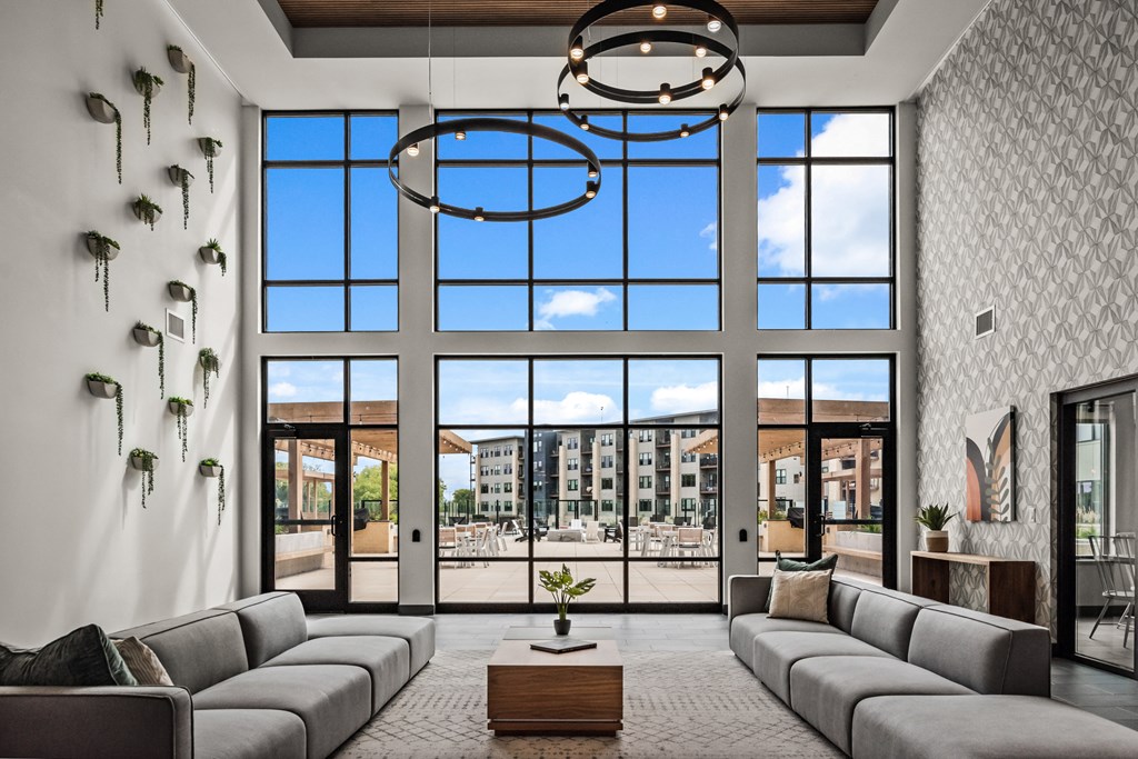 a living room with large windows and a couch and a table