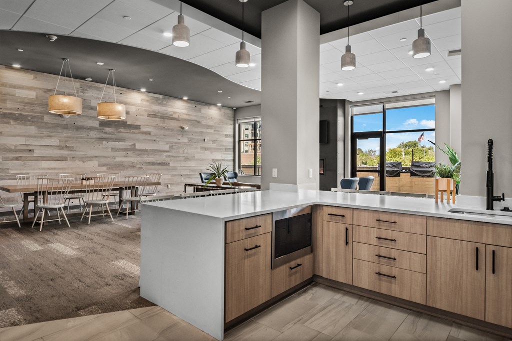 a kitchen with a large island and a dining room with tables and chairs