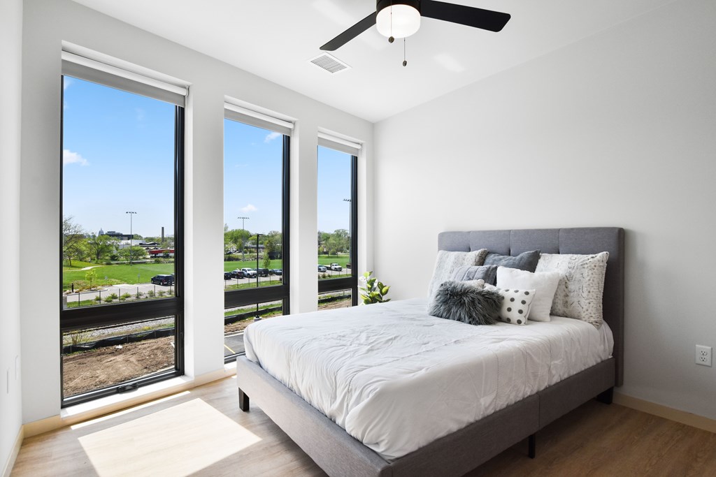 A bedroom with a large bed and a ceiling fan.