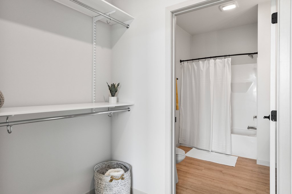 A white bathroom with a white shower curtain and a white towel.