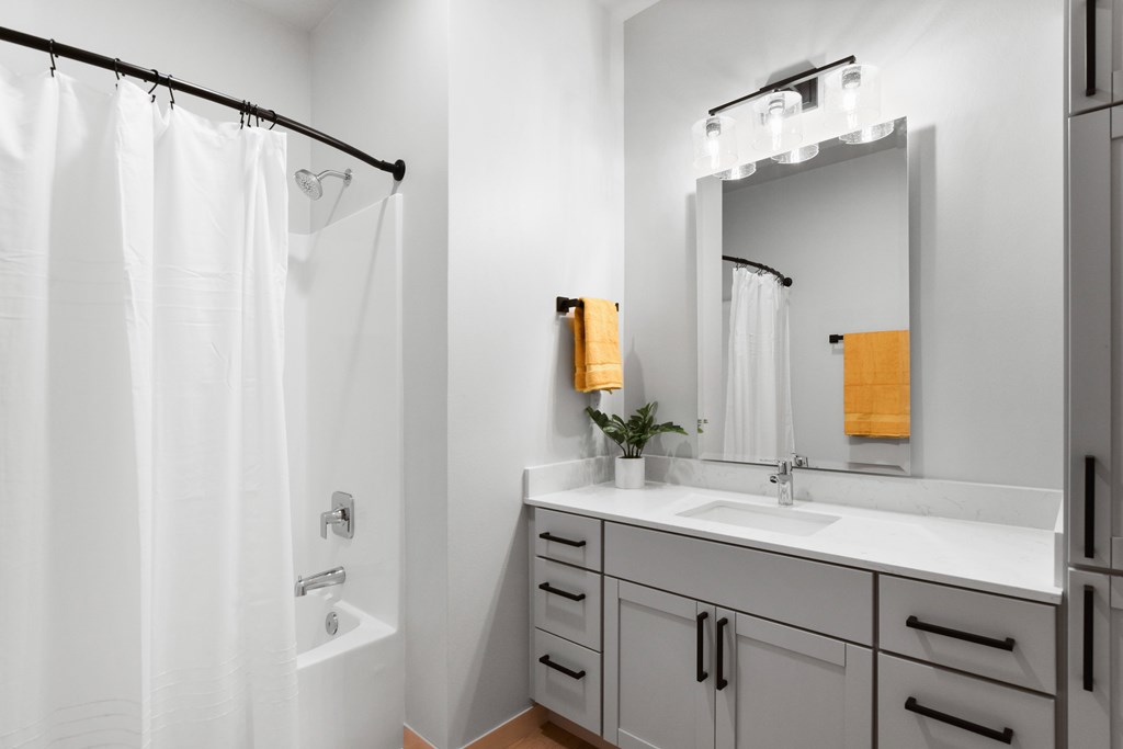 A white bathroom with a white tub and sink.