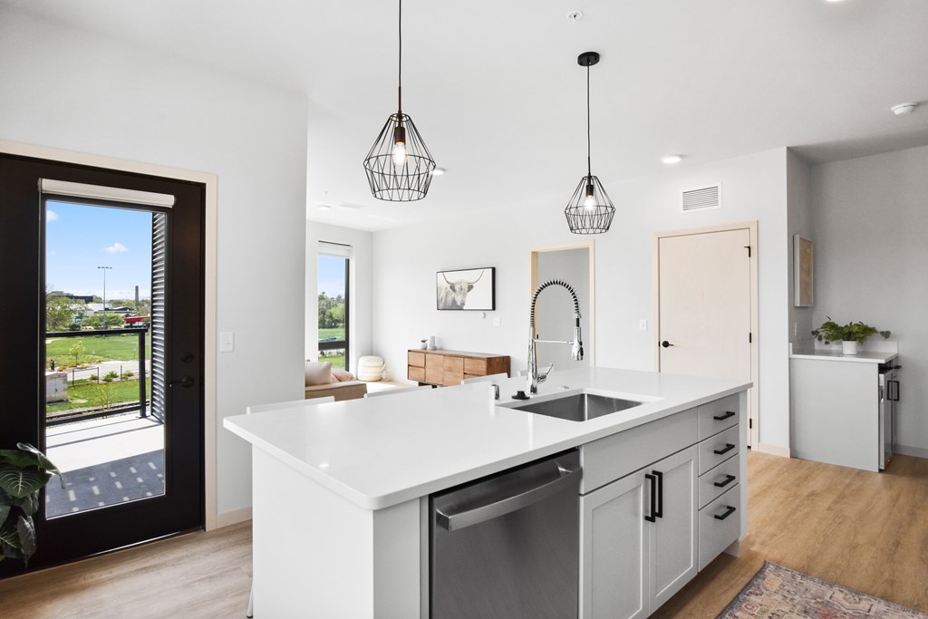 A modern kitchen with a large island and pendant lights.