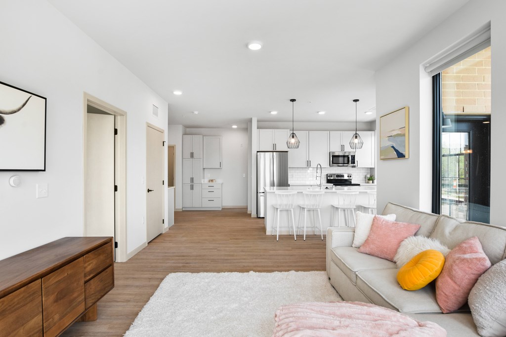 A modern living room with a grey couch and a white rug.