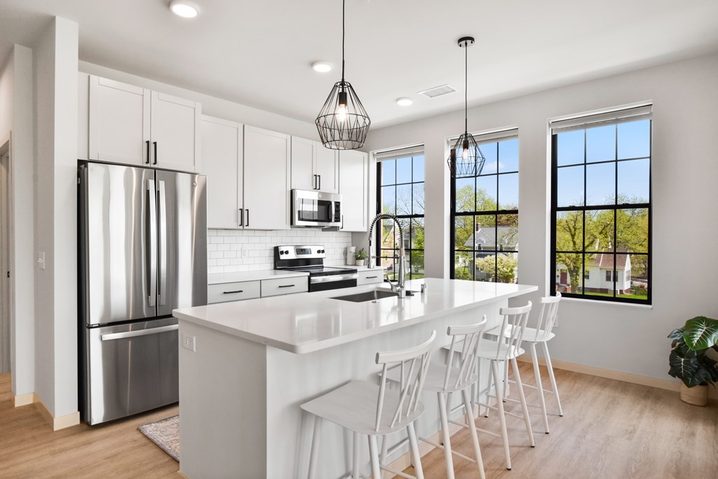 A modern kitchen with white cabinets and a large island.