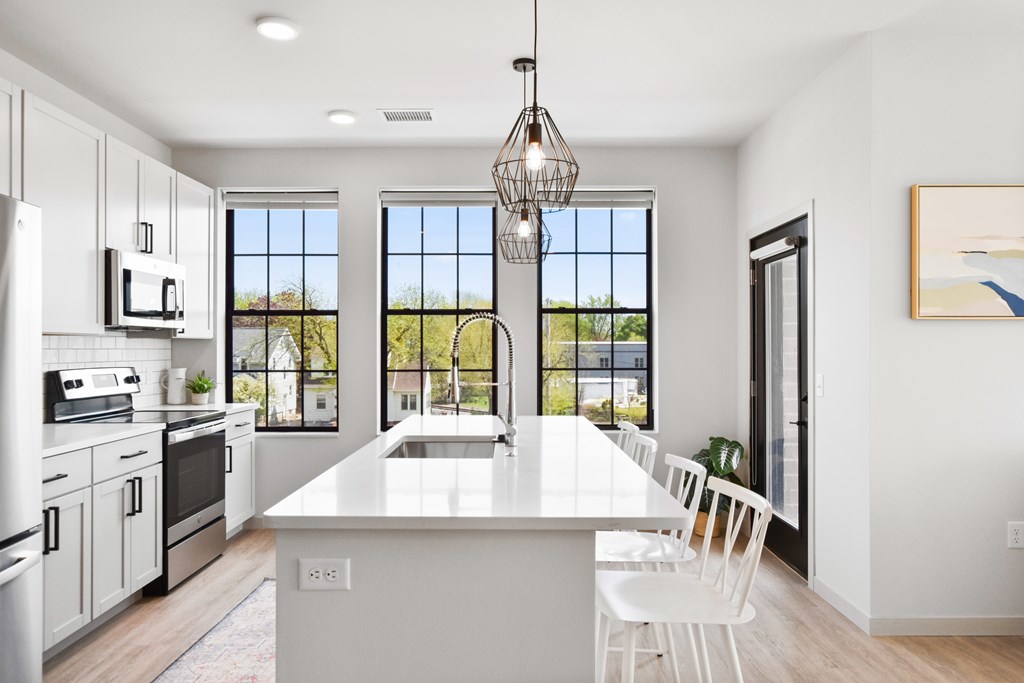 A modern kitchen with white cabinets and a large island.