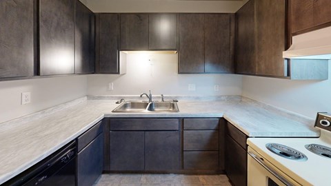 A modern kitchen with dark wood cabinets and a white countertop.