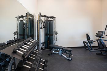 a fitness room with cardio machines and weights at The Landing at 1001 NP, Fargo, North Dakota 58102