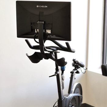 A stationary exercise bike with a monitor attached to the handlebars at Riverhouse Apartments, Fargo, North Dakota 58102
