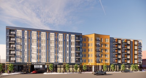 A modern multi-story building with a parking lot in front.