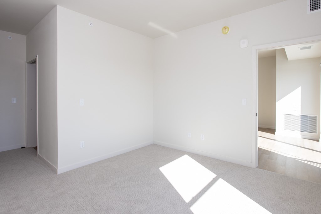 an empty living room with white walls and carpet at Riverhouse Apartments, North Dakota