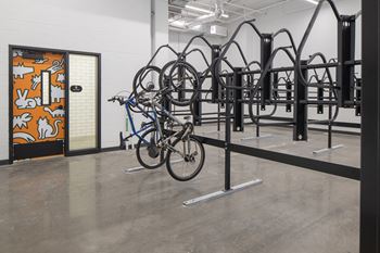 A bike rack with several bikes on it and a door with a mural on it  at Kesler Apartments, Fargo, North Dakota 58102