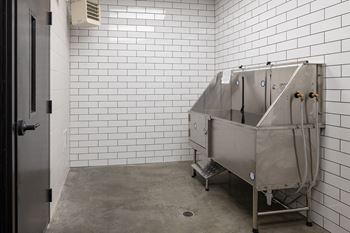 A large metal tub in a white tiled room at Kesler Apartments, Fargo, ND 58102