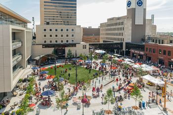 A large open plaza with people sitting and walking around.