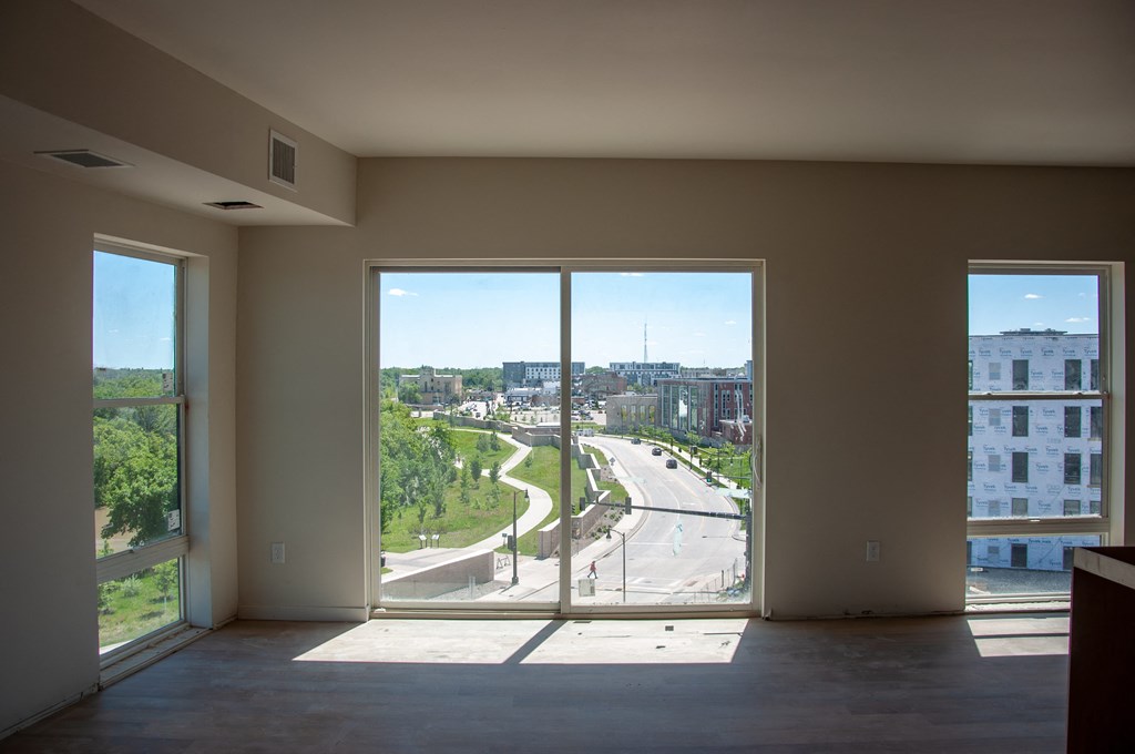 an empty living room with a view of a highway from a window