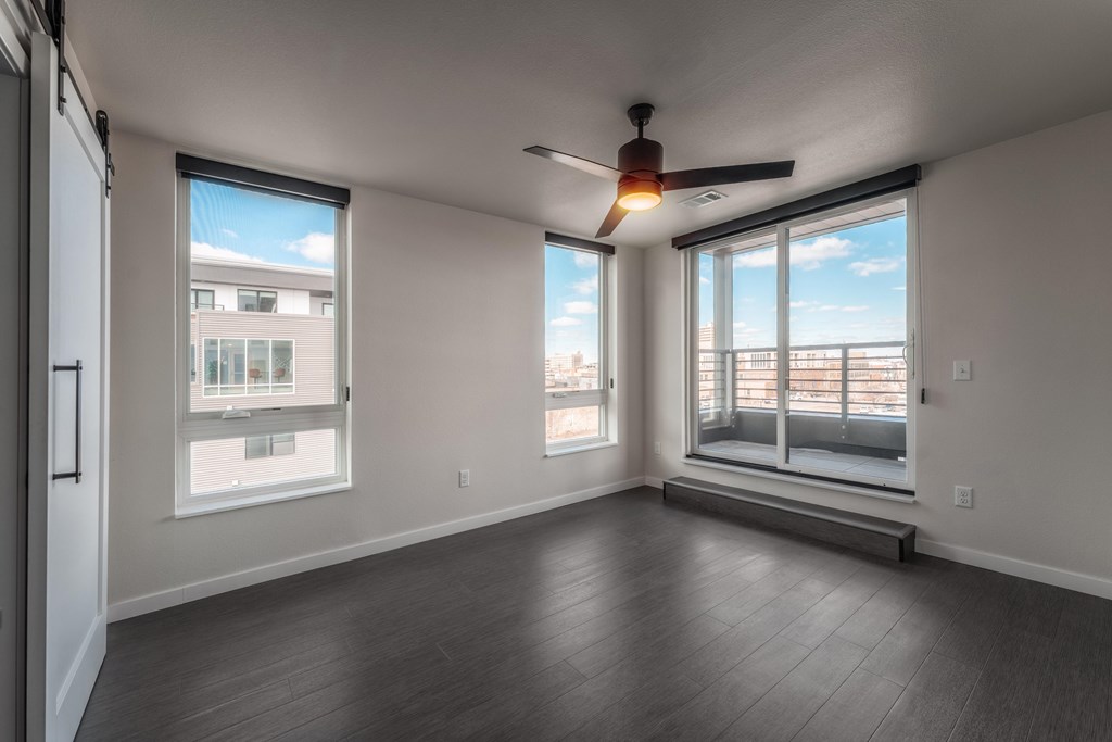 A room with a ceiling fan and large windows. at Unite Apartments, North Dakota, 58103