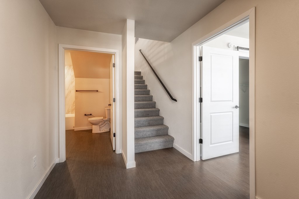 A hallway with a staircase leading to the second floor. at Unite Apartments, North Dakota, 58103