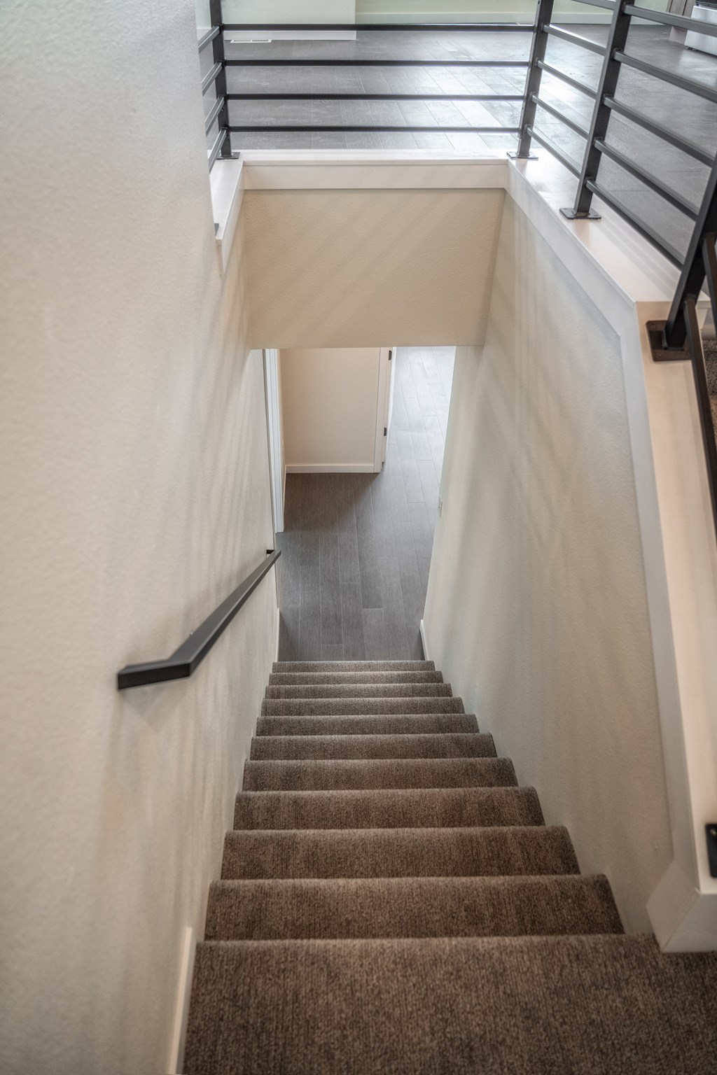 A staircase with a metal railing and carpeted steps. at Unite Apartments, North Dakota, 58103