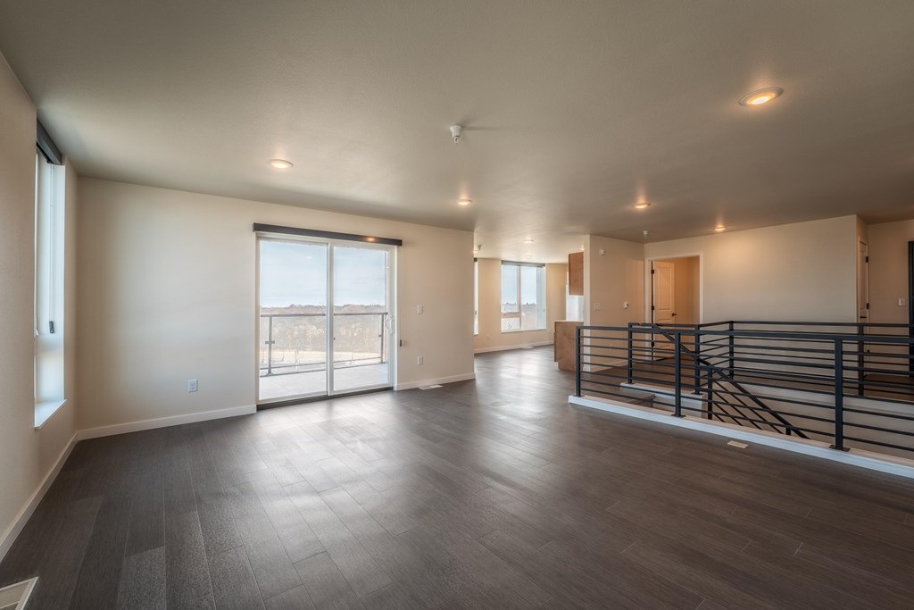 A spacious room with a balcony and sliding glass doors.