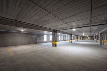 A spacious, empty parking garage with concrete floors and walls.