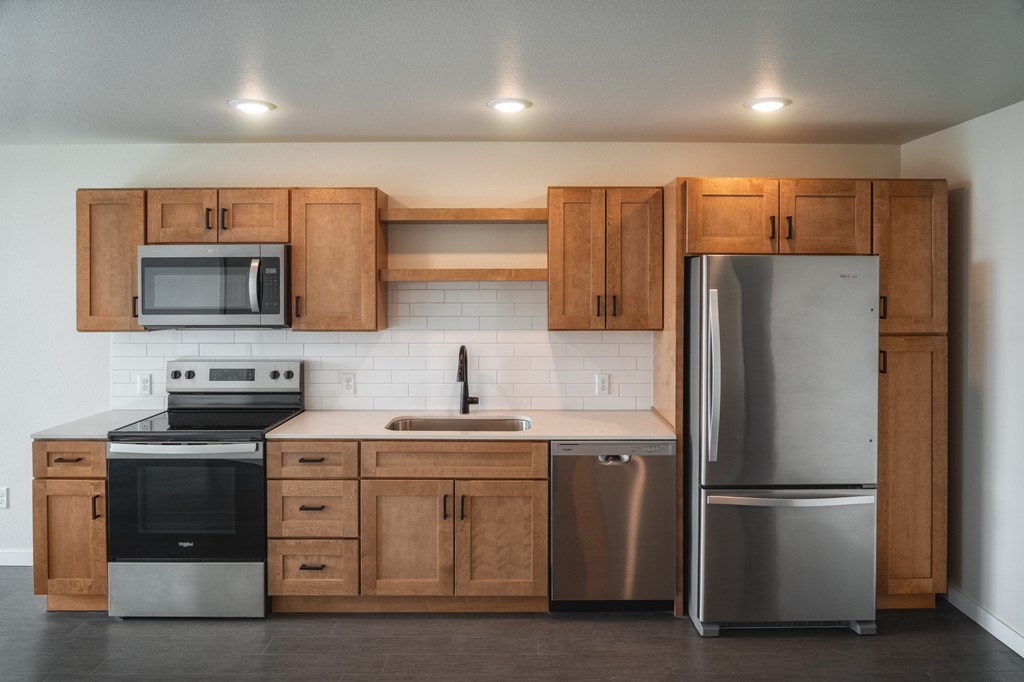 A kitchen with wooden cabinets and stainless steel appliances. at Unite Apartments, Fargo, ND, 58103
