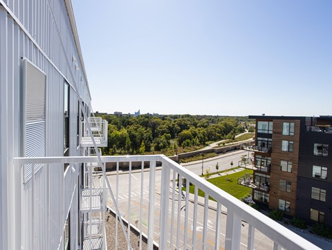 a balcony with a view of a park and some buildings at Riverhouse Apartments, Fargo
