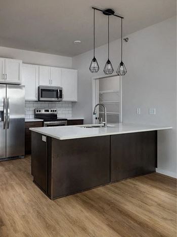 a kitchen with stainless steel appliances and a white counter top at Mercantile on Broadway, Fargo, ND 58102