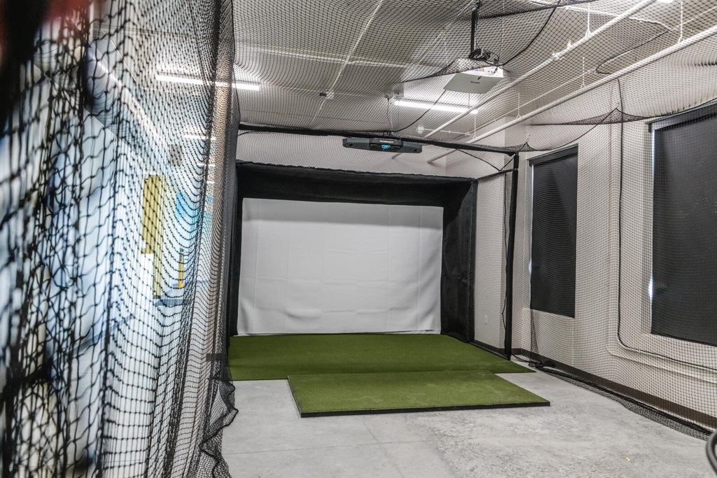 a batting cage in a gym with a green carpet at Riverhouse Apartments, Fargo