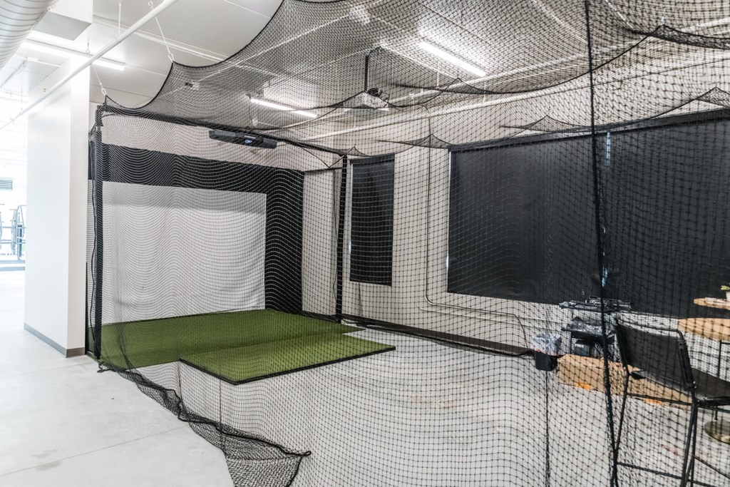 a batting cage in a room with nets and a table at Riverhouse Apartments, Fargo, North Dakota