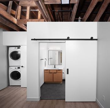 a bathroom with a washing machine and a sink and a washer and dryer at Bostad Apartments, Fargo, ND 58102
