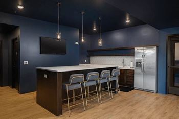 A kitchen with a bar area and chairs at Mercantile on Broadway, Fargo, ND 58102
