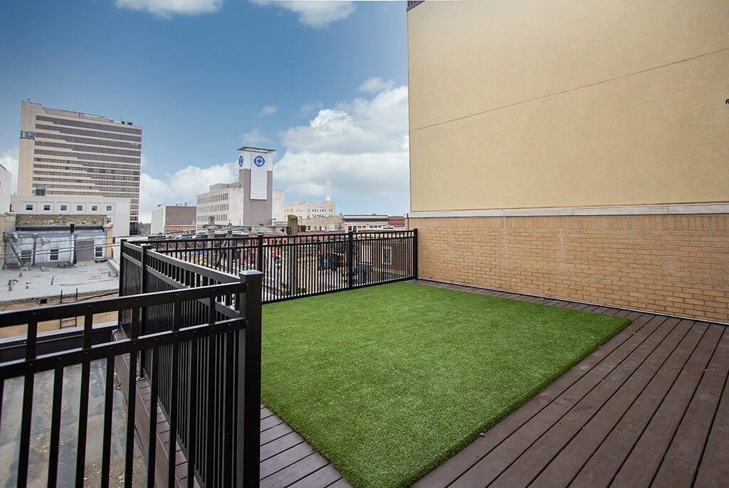 a small astroturf lawn on a balcony with a city in the background at RoCo Apartments, Fargo, ND 58102