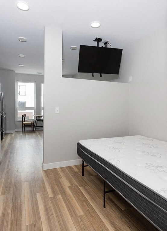 a bedroom with a bed and a tv on the wall  at RoCo Apartments, Fargo, North Dakota, 58102