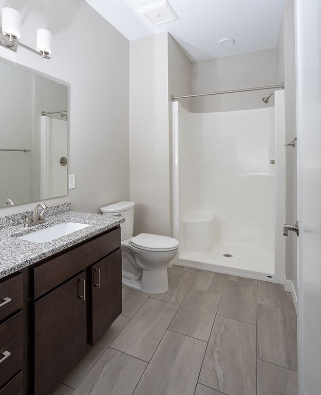 a bathroom with a toilet sink and shower  at RoCo Apartments, Fargo, ND 58102