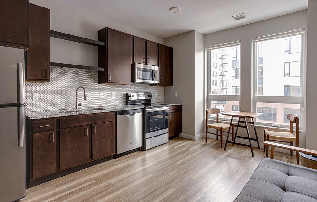 a kitchen with dark wood cabinets and stainless steel appliances  at RoCo Apartments, Fargo, North Dakota 58102