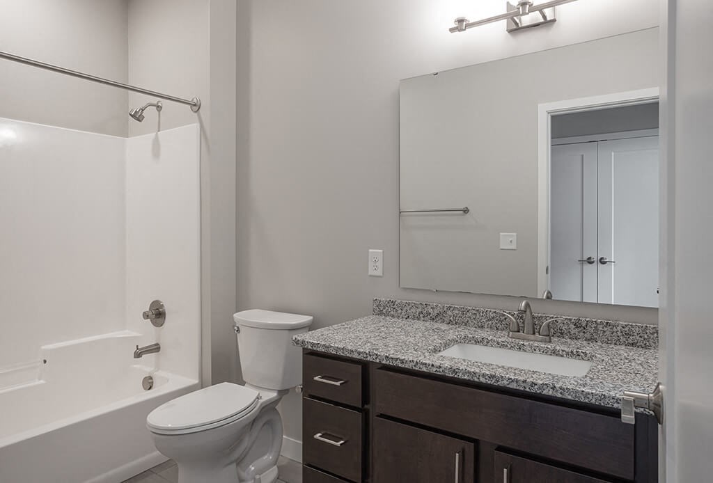 a bathroom with a toilet sink and shower  at RoCo Apartments, Fargo, ND 58102