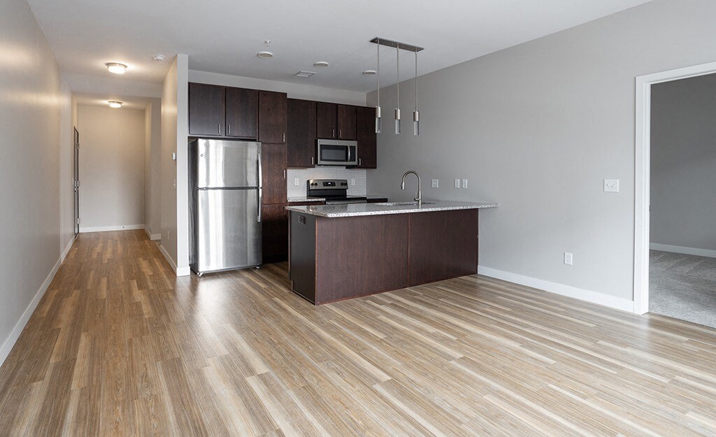 a kitchen with a large island and stainless steel appliances  at RoCo Apartments, Fargo, North Dakota 58102