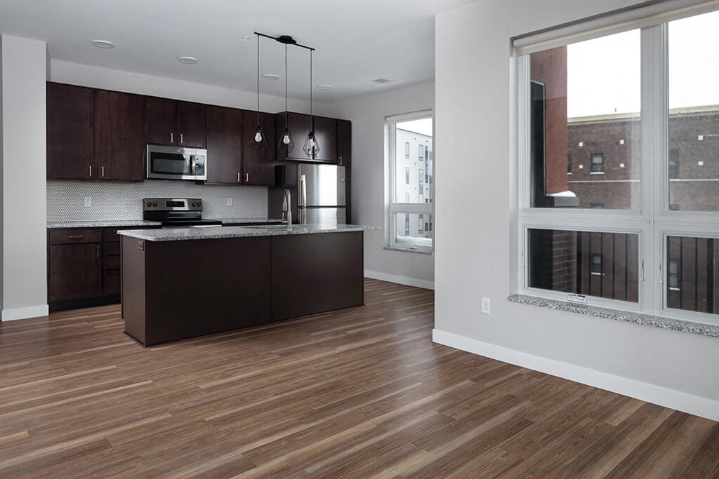 an open kitchen and living room with a large window  at RoCo Apartments, Fargo, ND 58102
