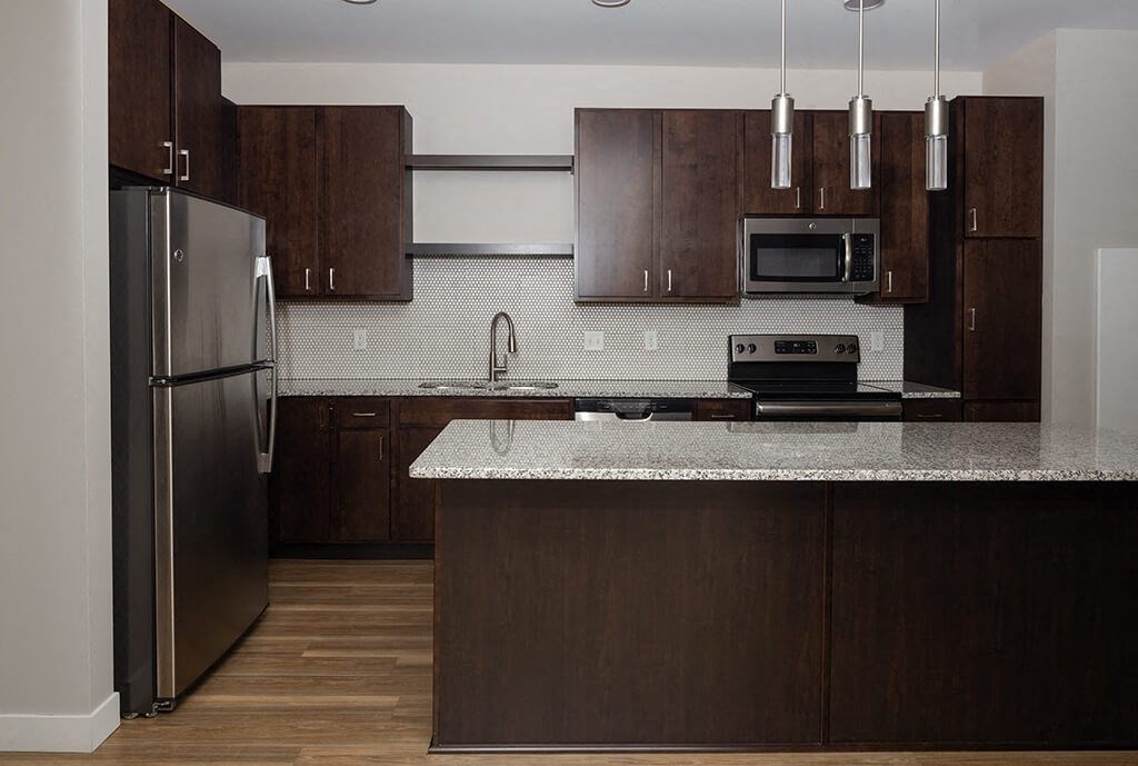 a kitchen with dark wood cabinets and a white counter top  at RoCo Apartments, Fargo, ND 58102