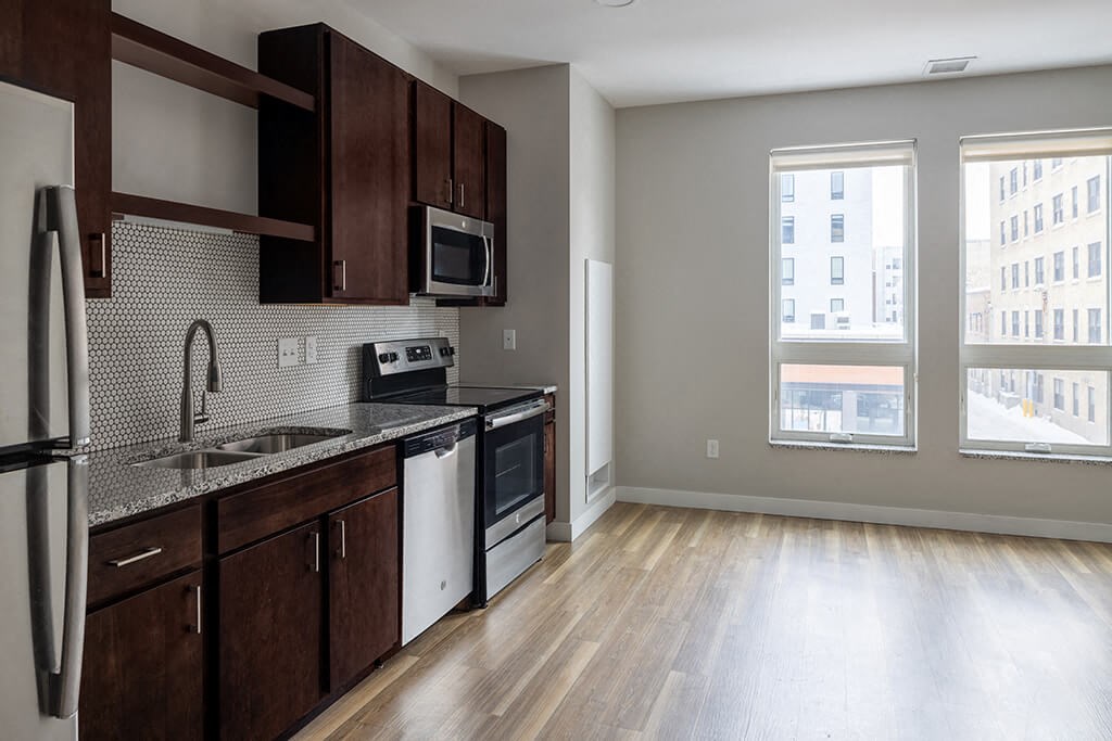 a kitchen with a stove top oven next to a window  at RoCo Apartments, Fargo, North Dakota 58102
