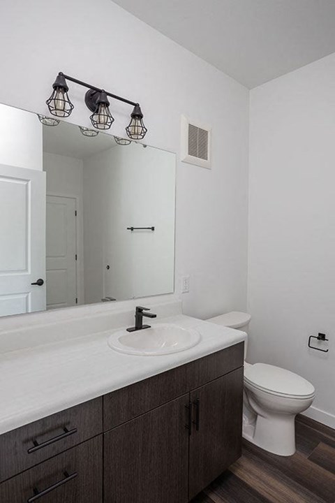 a bathroom with a sink toilet and mirror at The Landing at 1001 NP, Fargo, North Dakota 58102