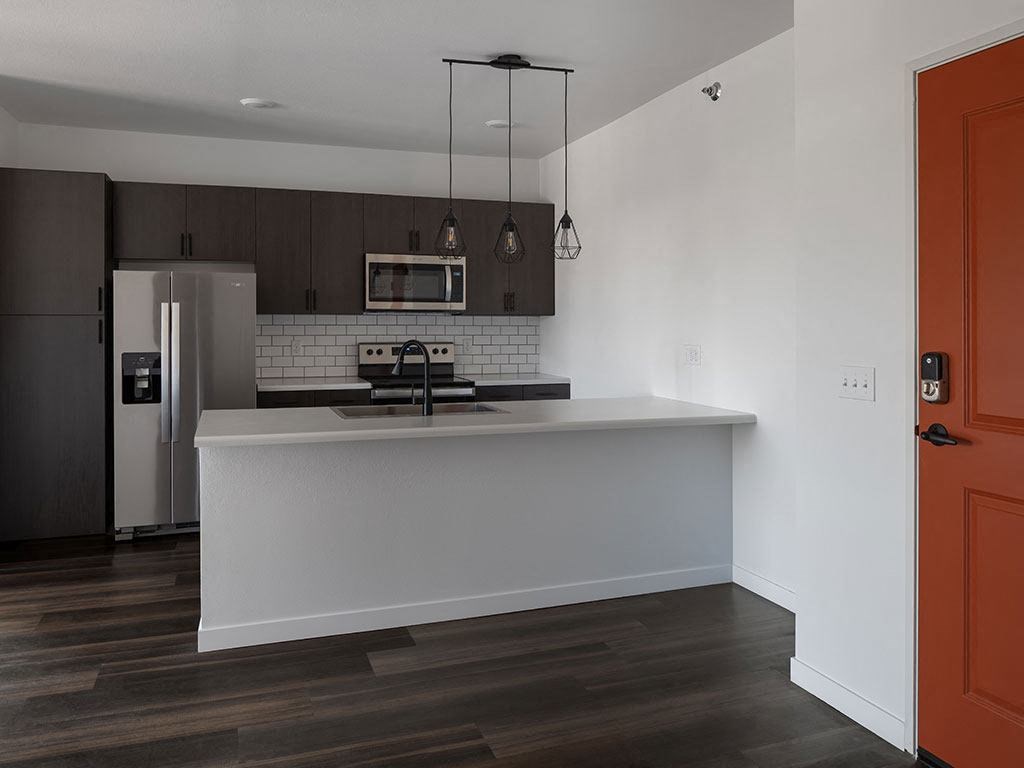 a kitchen with a white counter top and a stainless steel refrigerator at The Landing at 1001 NP, Fargo, ND, 58102