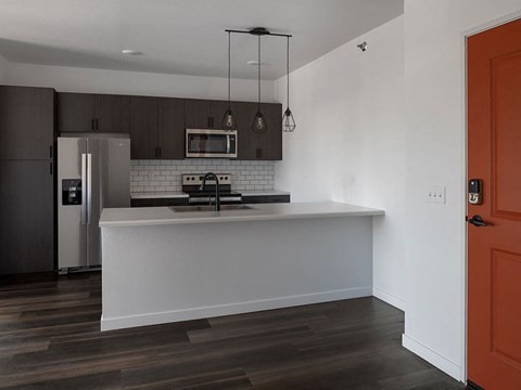 a kitchen with a white counter top and a stainless steel refrigerator at The Landing at 1001 NP, Fargo, ND, 58102